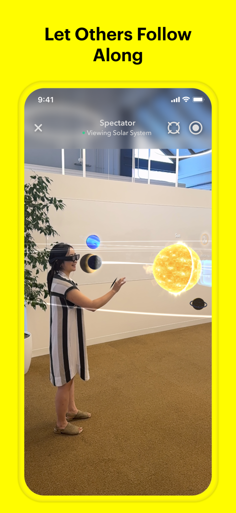 Spectacles by Snap Inc. - Smartphone screen showing the Spectator feature in the Spectacles app where a friend watches a person interact with an AR solar system