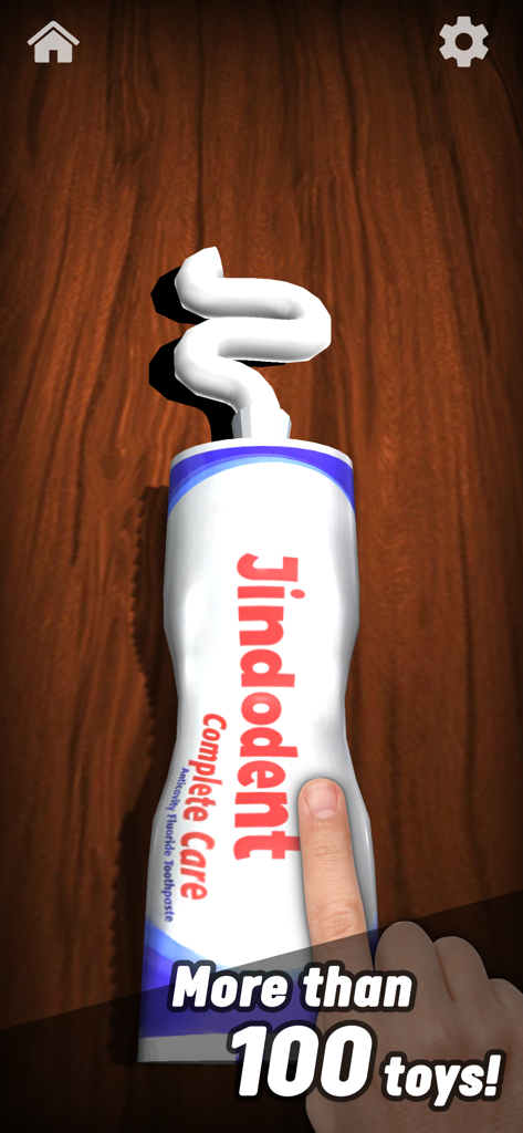 A hand squeezing a virtual tube of toothpaste on a wooden background in the Antistress app.