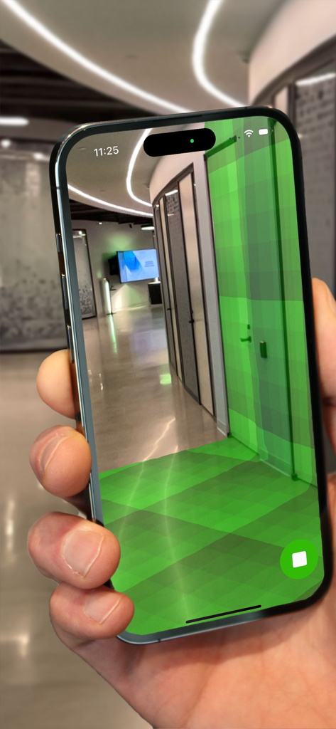 Pantalla de iPhone que muestra una malla de realidad aumentada verde escaneando un pasillo de oficina