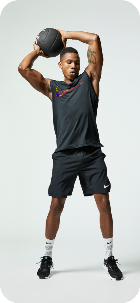 Hombre con ropa deportiva Nike sosteniendo un balón medicinal