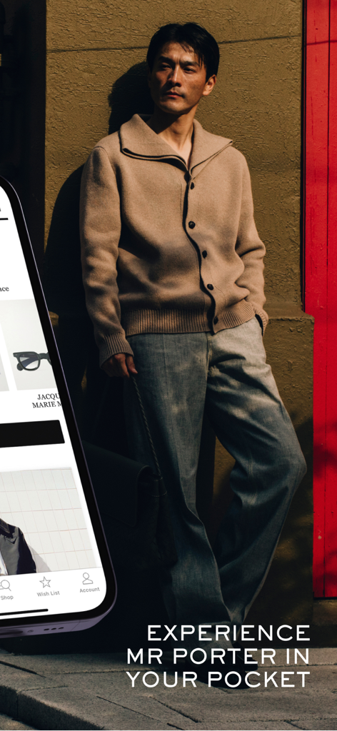 MR PORTER: Shop men’s fashion - MR PORTERアプリのインターフェースを表示するスマートフォンを横に、スタイリッシュな服装の男性