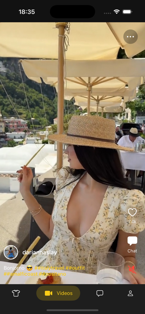 Qavra - A travel outfit video post on the Qavra social fashion app featuring a floral dress and straw hat in Positano