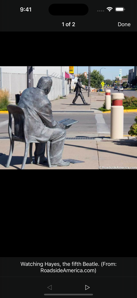 Roadside Presidents - Bronze statues of presidents on a city sidewalk featuring a seated figure watching another walk across the street