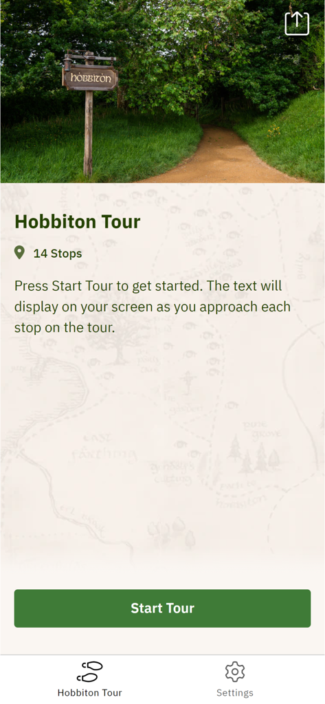 Interfaz de la aplicación móvil del tour de Hobbiton que muestra la pantalla de inicio del tour con una foto de un camino de La Comarca y un letrero de madera.