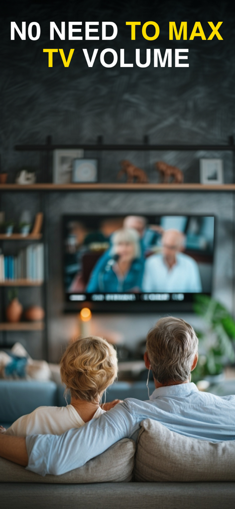 Hearing Aid: Listening Device - An elderly couple sitting on a couch watching TV while the man uses earphones to hear better