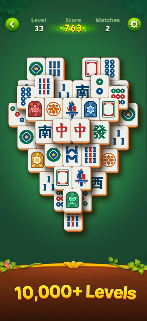 A mahjong board with tiles arranged in a heart shape on a green background