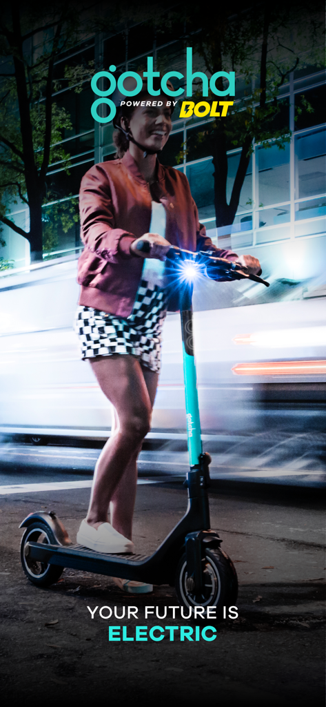 A person riding a Gotcha electric scooter on a city street at night