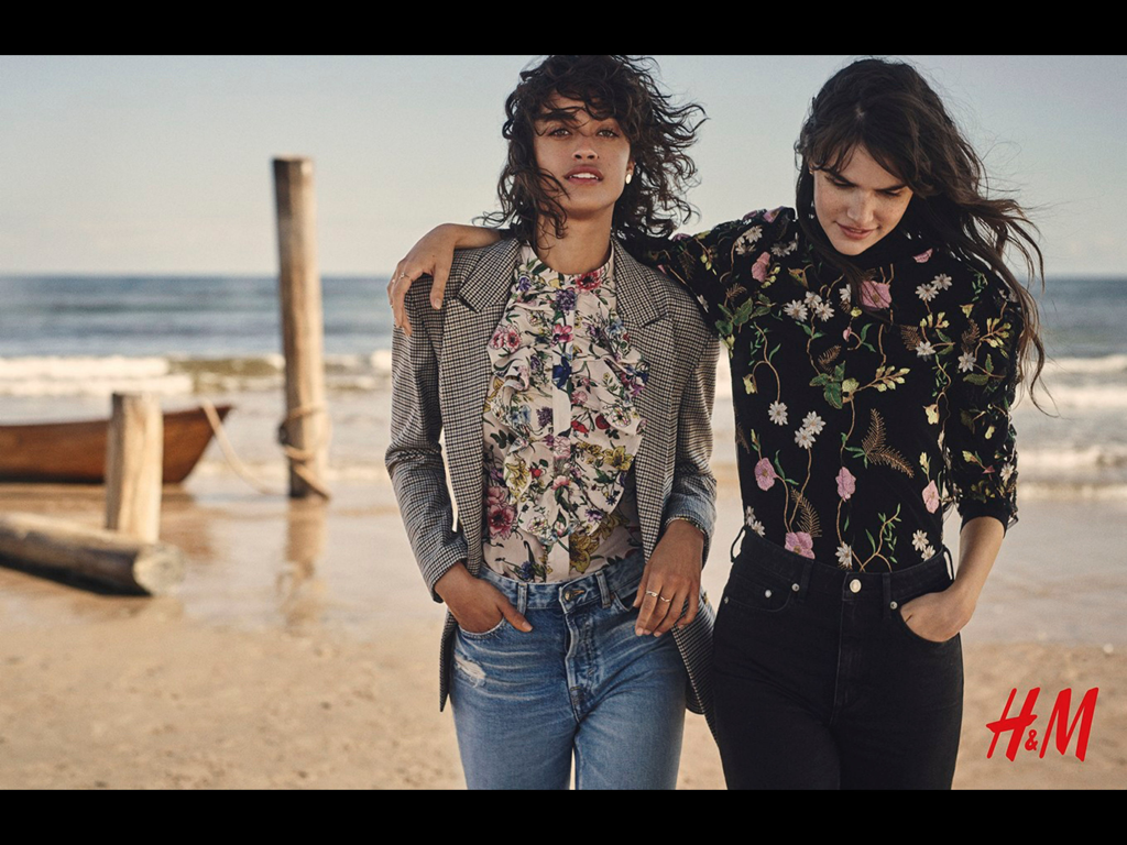Ein professionelles Modeportfolio-Foto mit zwei Models in Blumenoutfits am Strand für eine HM-Kampagne.