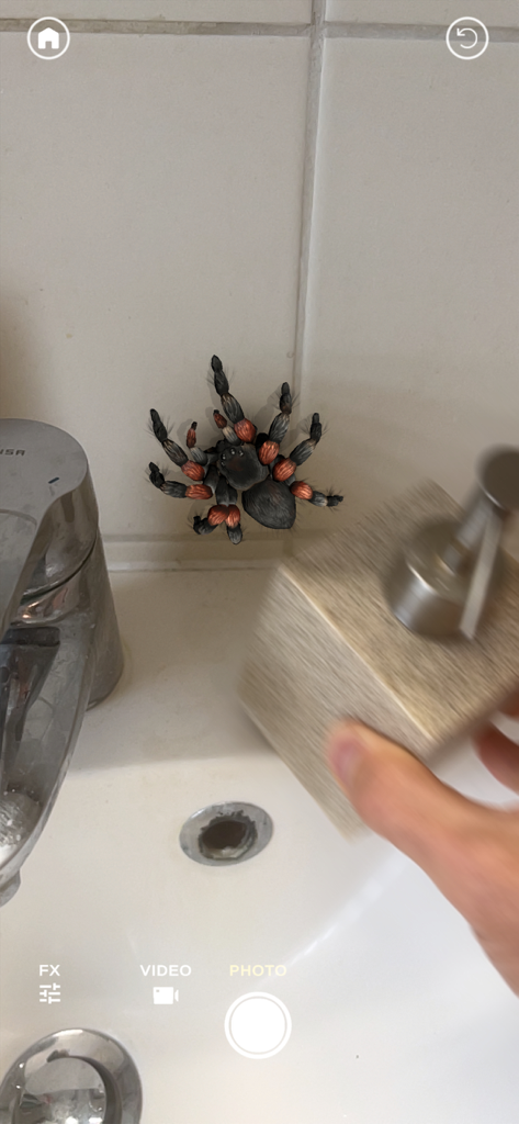 Eine realistische AR-Vogelspinne, die auf einer Badezimmerwand in der Nähe eines Waschbeckens für einen Streich krabbelt