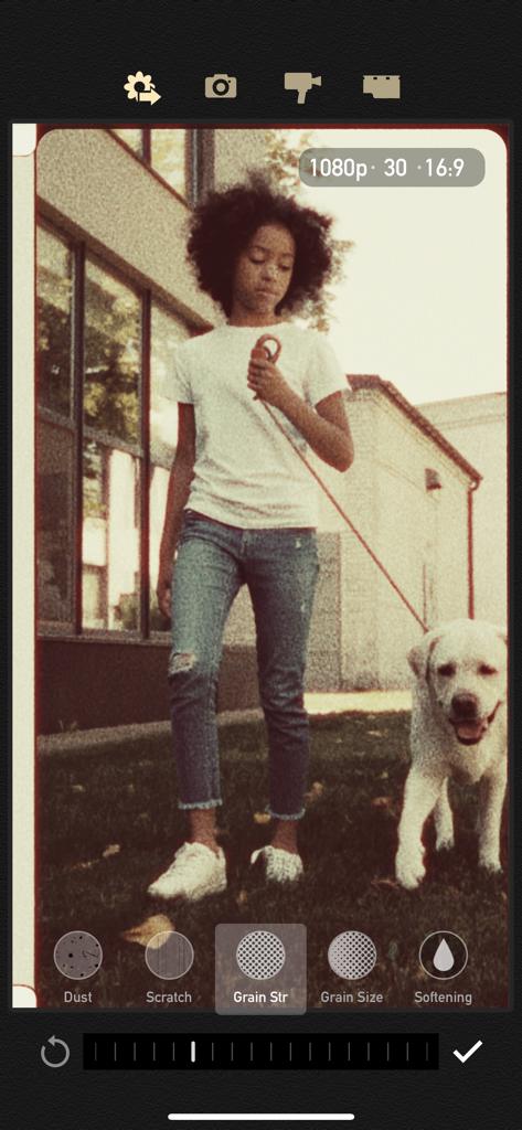 Interfaz de edición de la aplicación Cámara Vintage de 8mm con efectos de grano de película aplicados a un video de una niña y su perro.