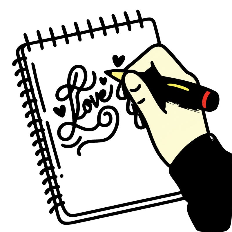 a hand writing “love” in calligraphy on a notebook