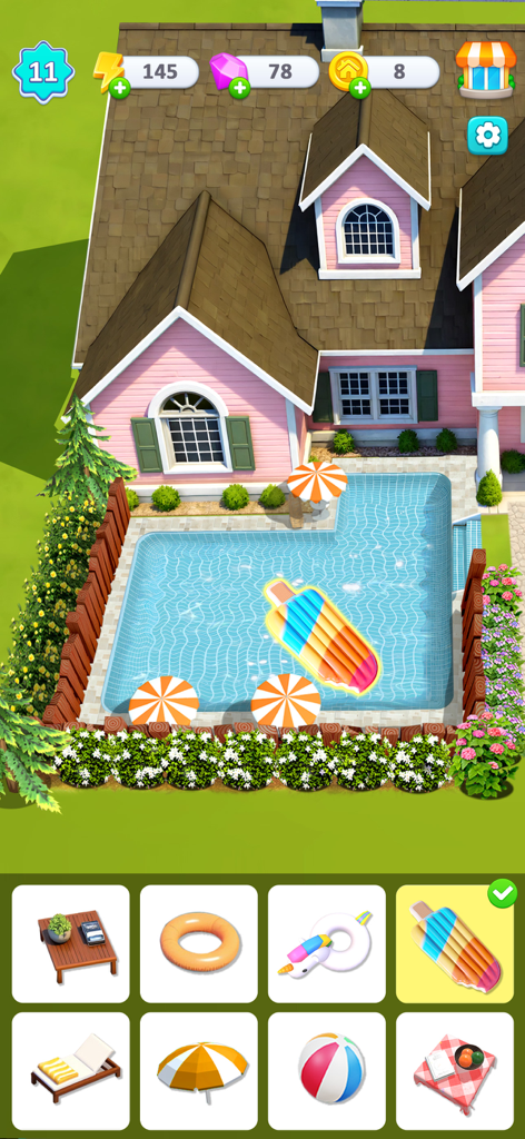 Happy Merge Estate - A gameplay screenshot of Happy Merge Estate showing a pink house and a backyard pool being decorated with colorful summer accessories like a popsicle float.
