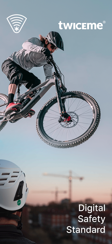 Un mountain biker in aria e un professionista con un casco di sicurezza con il logo Twiceme