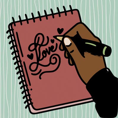 a hand writing “love” in calligraphy on a notebook