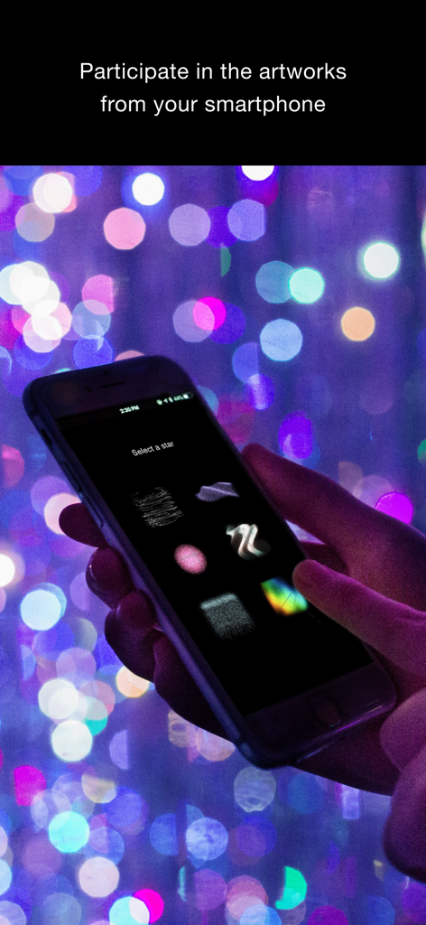Persona che usa l'app teamLab su uno smartphone per interagire con una mostra luminosa immersiva