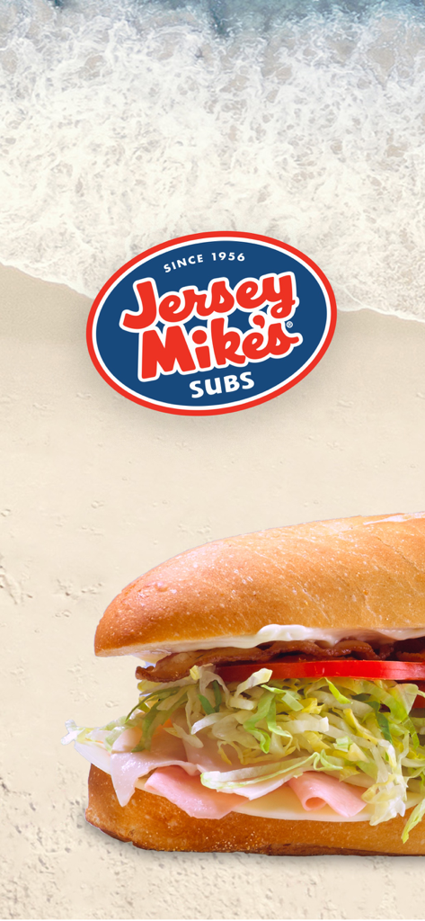 A fresh Jersey Mikes sub sandwich displayed over a sandy beach and ocean waves background