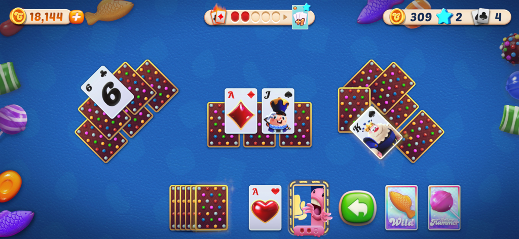 Candy Crush Solitaire - Gameplay screen of Candy Crush Solitaire showing a TriPeaks card layout with candy-themed designs and boosters.