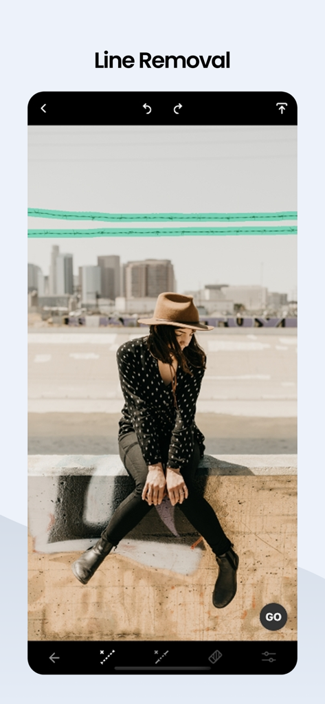 Pantalla móvil que muestra la herramienta de eliminación de líneas de TouchRetouch resaltando los cables eléctricos a borrar de una foto de paisaje urbano