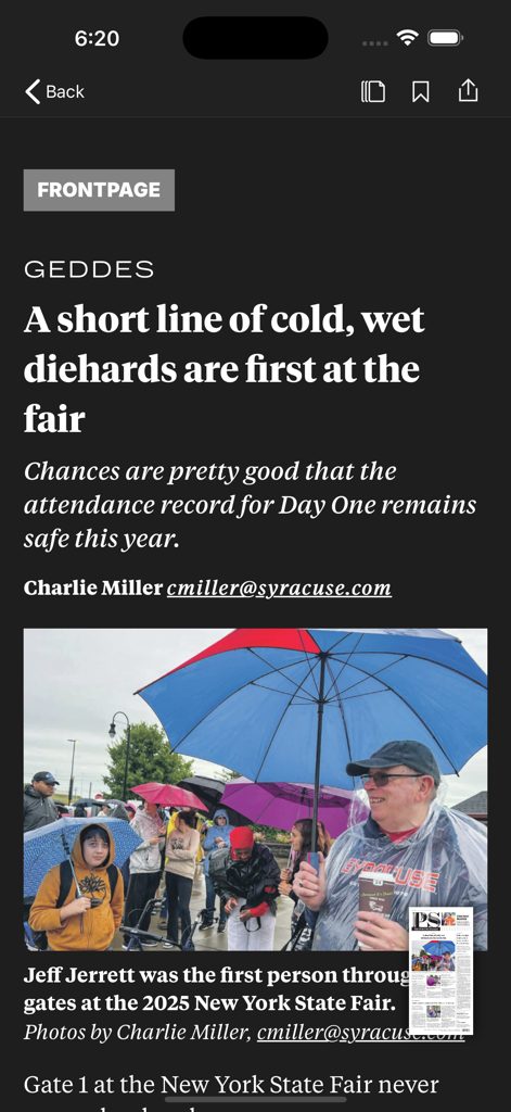 The Post-Standard - A screenshot of The Post-Standard news app displaying an article about the New York State Fair with a photo of attendees under umbrellas.