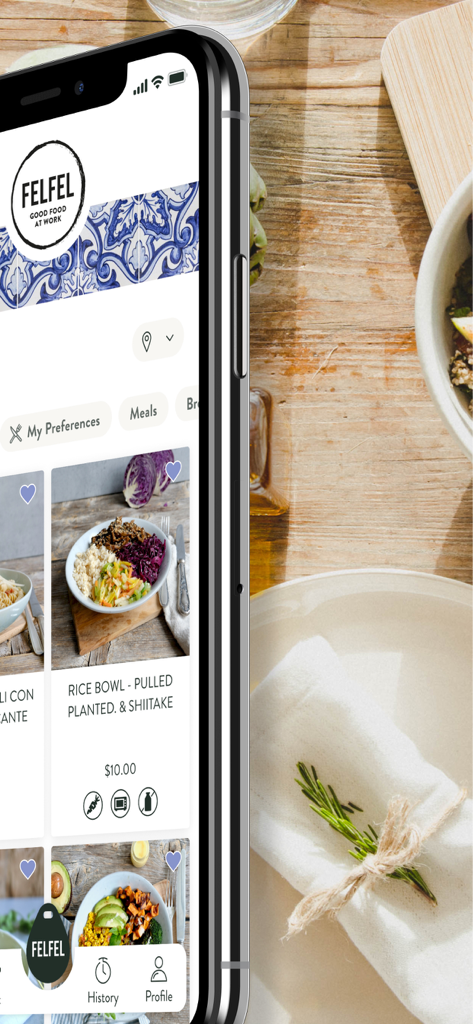 Smartphone displaying the FELFEL app menu with healthy workplace meal options like rice bowls.