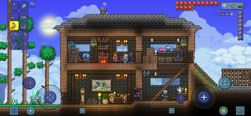 Una casa detallada de madera de dos pisos en el juego móvil Terraria, con varios PNJ y decoraciones interiores.