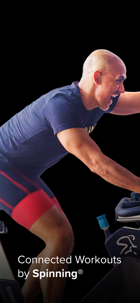 Spinning Indoor Cycling - Um instrutor homem liderando uma sessão de ciclismo indoor conectada em uma bicicleta Spinning