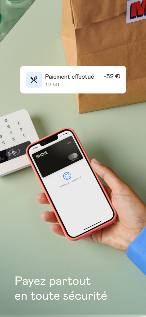 Shine - Compte pro en ligne - Une personne utilisant l'application Shine pour un paiement sans contact sécurisé sur un iPhone dans un magasin
