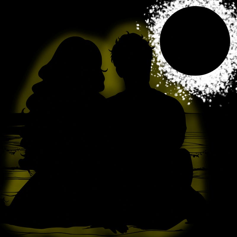 realistic couple on beach sat looking out to sea under the moon woman has long wavy hair man has short hair