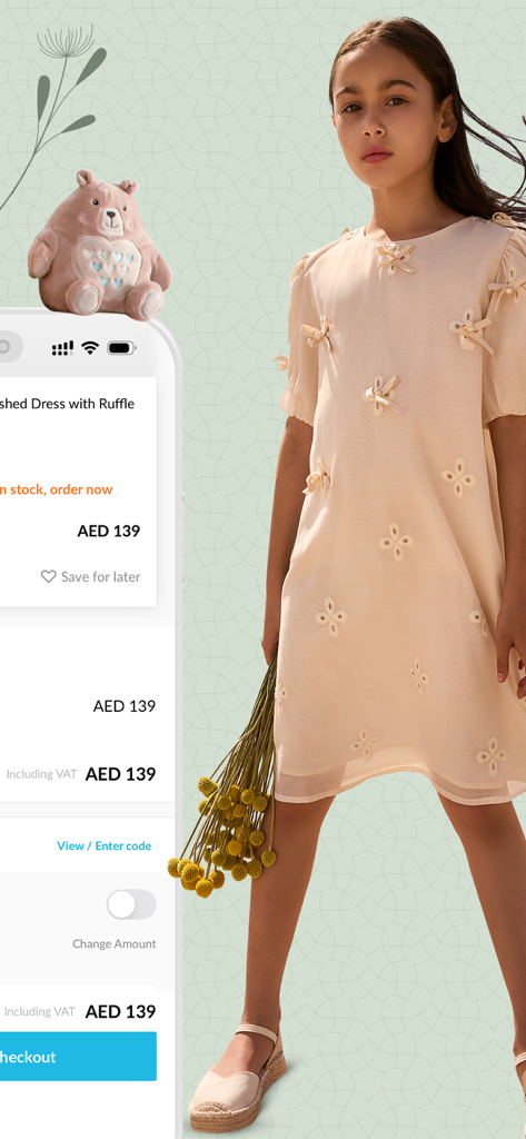 Babyshop - محل الأطفال - Uma menina usando um vestido creme decorado ao lado da tela de finalização de compra do aplicativo Babyshop mostrando o preço do produto
