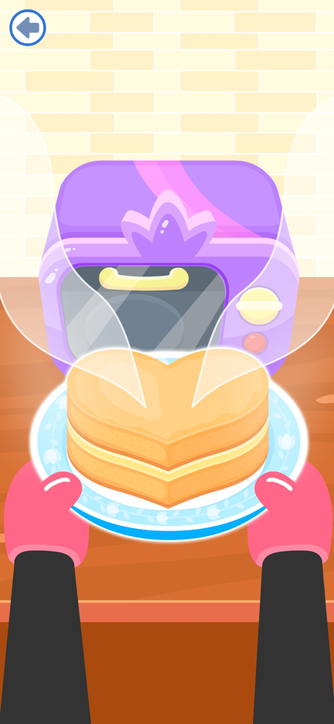 Donut Maker Games for Kids 4-5 - A heart shaped cake being held by pink oven mitts in front of a purple toy oven in a baking game for kids.