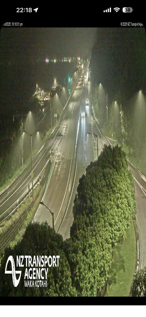 Nighttime traffic camera view of a multi-lane highway with streetlights