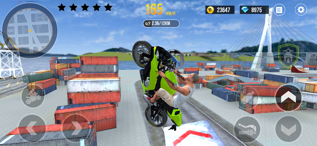 A green motorcycle performing a wheelie stunt in a shipping container yard.