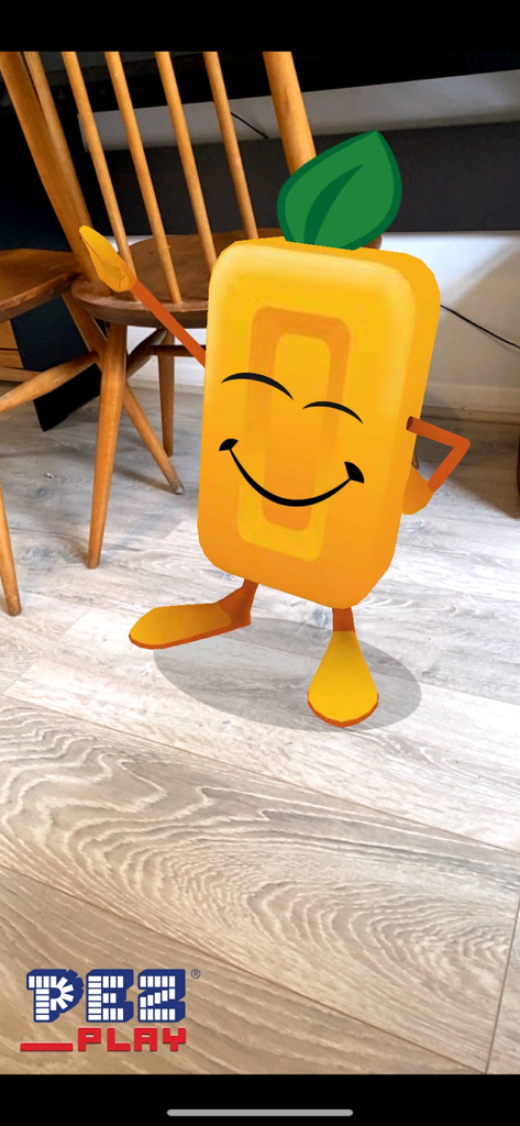A yellow PEZ character appearing in a real world room through augmented reality