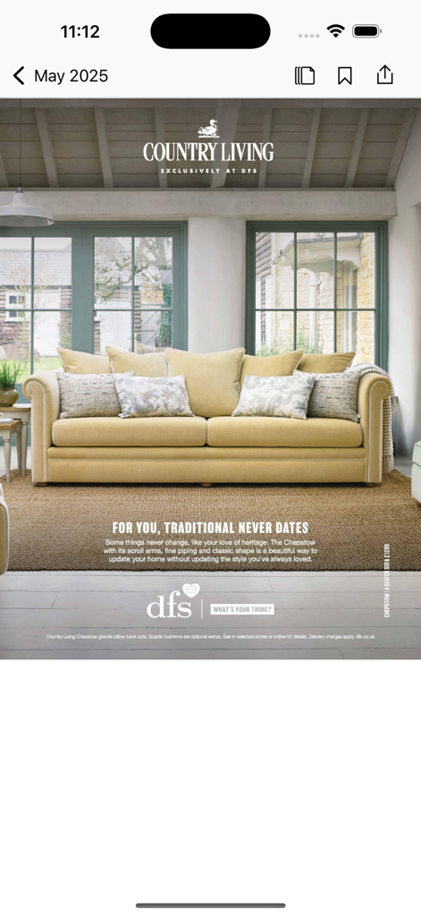 Country Living UK - Country Living UKアプリのページ。素朴なインテリアに伝統的な黄色のソファが置かれている。