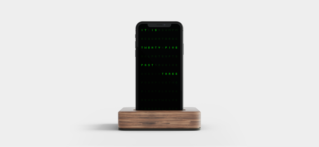 Pixel Clock - Retro Style - A smartphone on a wooden charging stand displaying a retro green pixelated word clock