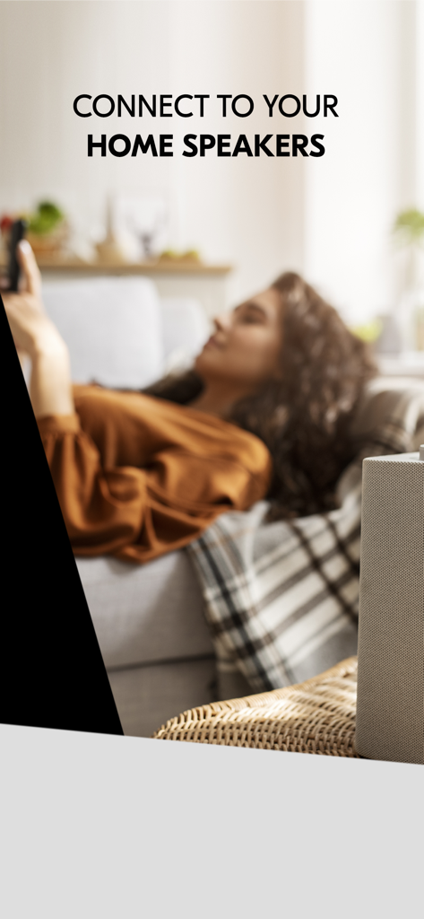 IDAGIO Stream Classical Music - A woman relaxing on a sofa while connecting her classical music stream to home speakers