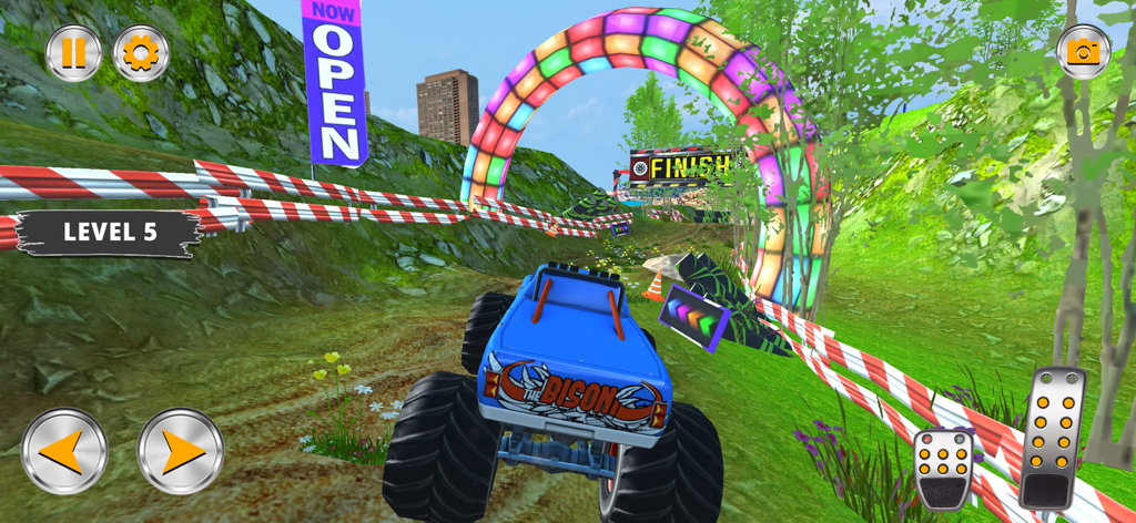 A blue monster truck driving through a grassy off-road track towards a finish line in a 4x4 simulator game