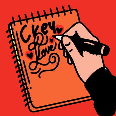 a hand writing “love” in calligraphy on a notebook