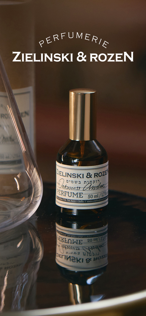 Zielinski&Rozen духи,косметика - Une bouteille de parfum Zielinski and Rozen Oakmoss Amber avec un bouchon doré sur une surface sombre réfléchissante.
