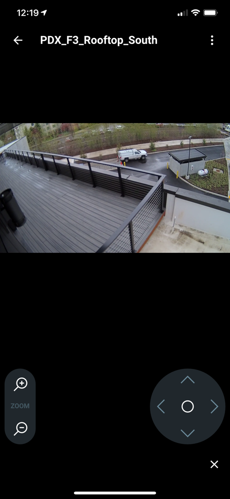 Piko VMS - Piko VMS Mobile App zeigt eine Live-Sicherheitskameraansicht eines Daches mit Zoom- und Schwenksteuerungen