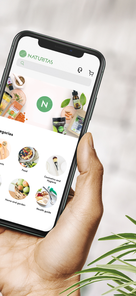 Hand holding a smartphone showing the Naturitas app interface with health and wellness product categories