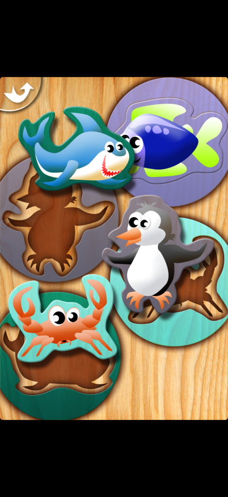 My First Puzzles - Pantalla de juego educativo para niños pequeños mostrando piezas de puzles de animales marinos y formas que coinciden en un tablero de madera.