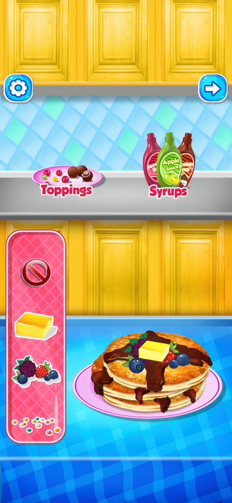 Una pila de tortitas decorándose con mantequilla, bayas y sirope de chocolate en un juego de simulación de cocina.