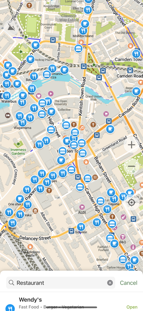CoMaps - Una vista mappa dettagliata di un'area urbana nell'app CoMaps con numerose icone per ristoranti, negozi e opzioni di trasporto con una barra di ricerca in basso.
