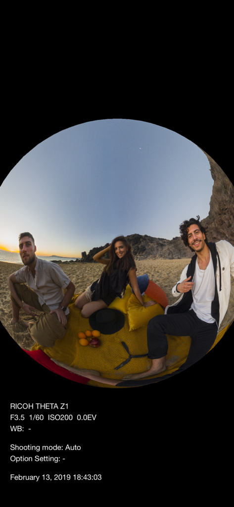 A circular 360-degree spherical photo of three people on a beach at sunset