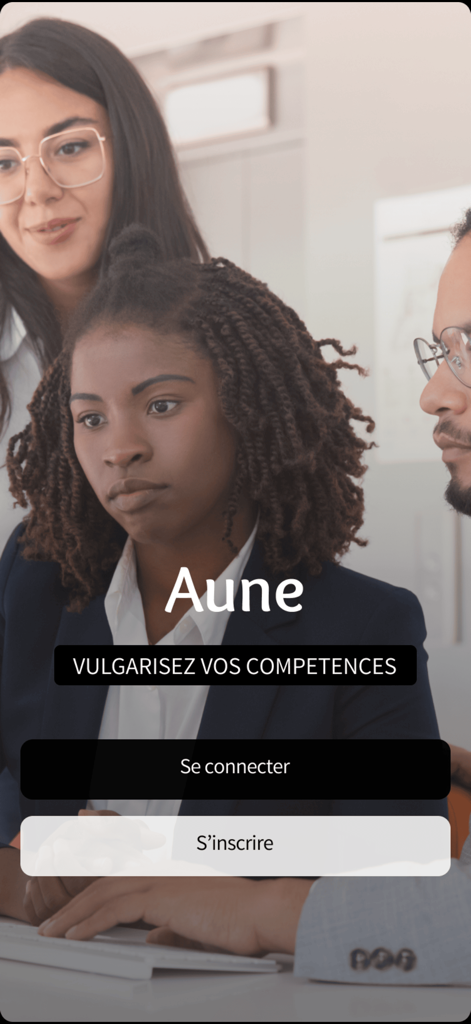 Auneアプリのウェルカム画面、オフィスにいるプロフェッショナルな従業員、ログインとサインアップのオプションが表示されています