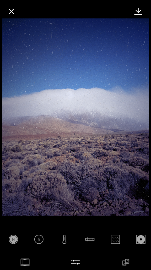 FILCA - Film Camera Filter - A landscape photo with a vintage film grain texture being edited in the FILCA app.