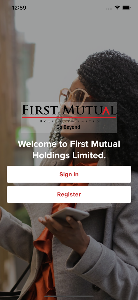 Pantalla de bienvenida de la aplicación First Mutual Holdings que muestra los botones Iniciar sesión y Registrarse sobre una imagen de una mujer profesional sonriente.