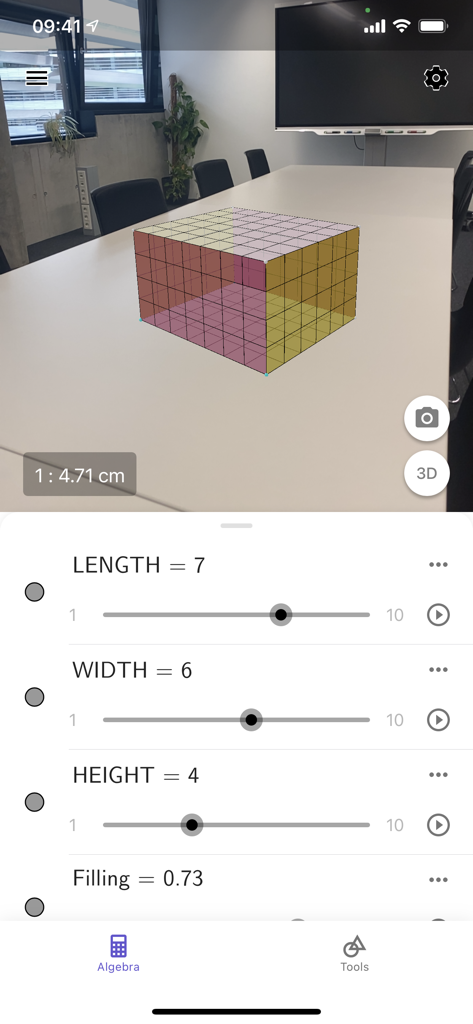 Geometric prism displayed in augmented reality on a table with adjustable dimension sliders in the GeoGebra 3D Calculator app