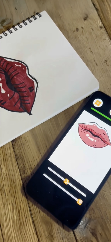 ArtLoop: Ar Drawing Lessons - A smartphone using ArtLoop AR technology to trace a lips illustration into a physical sketchbook
